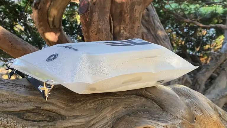 HEAT.me Lunchbag mit Kondenswasser innen, ein Zeichen für die warme Mahlzeit, ruht auf verwittertem Pinienstamm in natürlicher Umgebung.