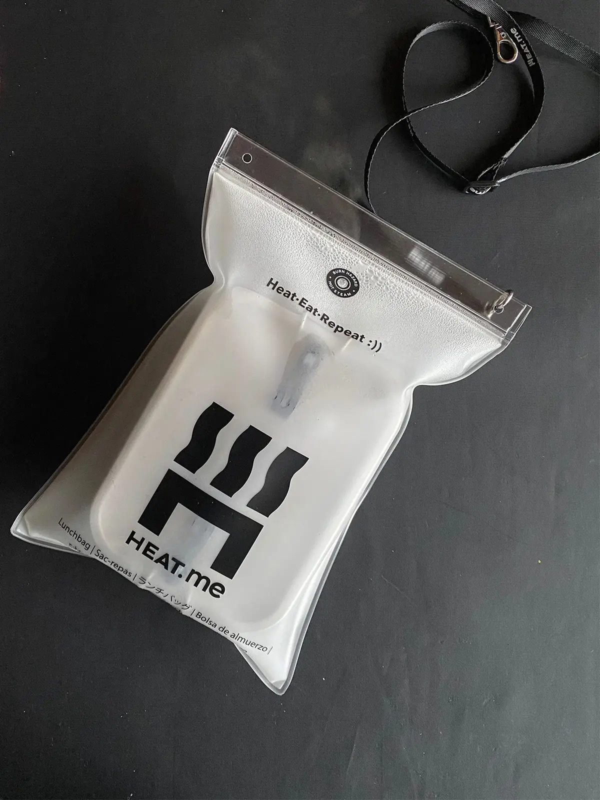 The HEAT.me Lunchbox Kit is shown on a black table with white, escaping steam