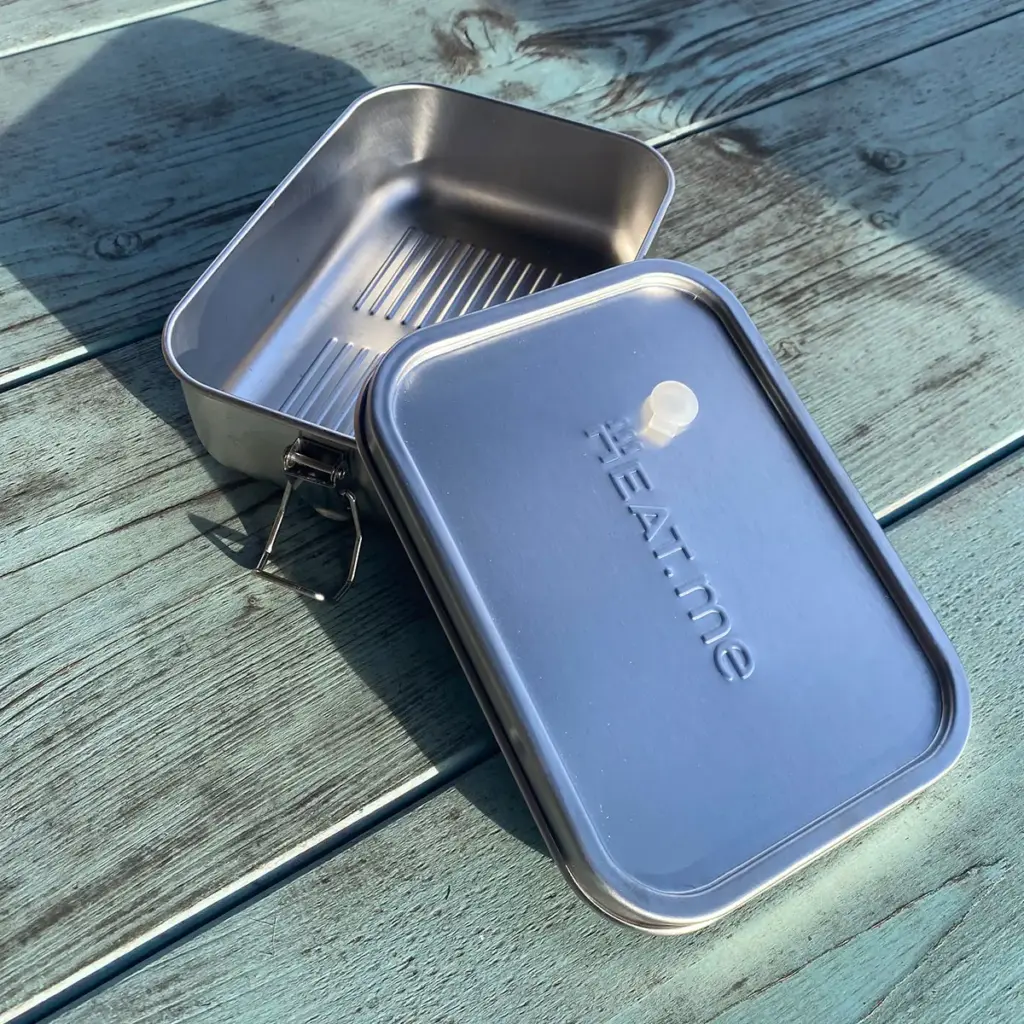 Premium Lunchbox auf grünem Tisch, geöffnet.
