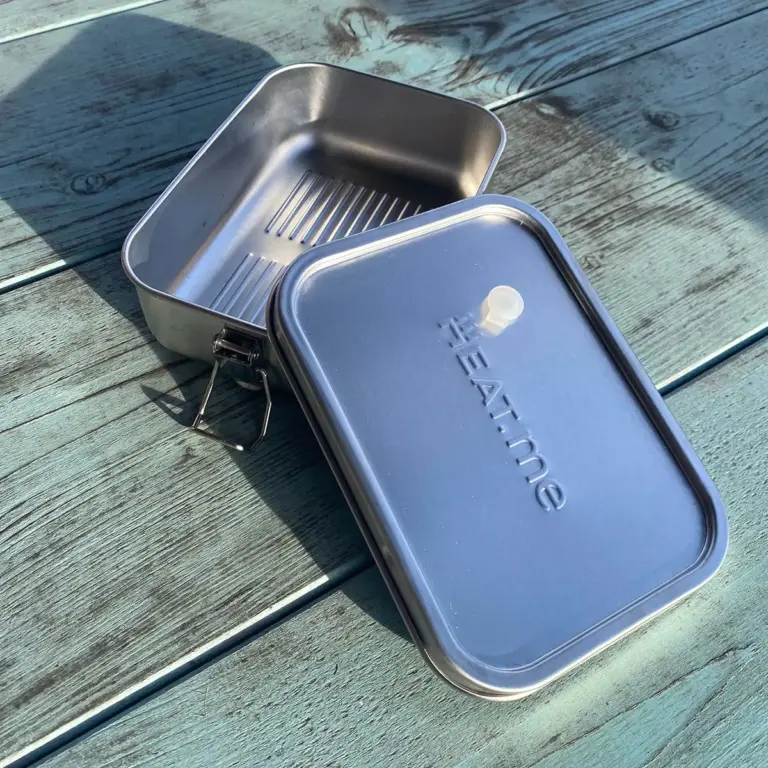 Premium lunch box on green table, open.