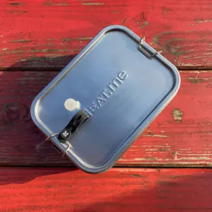 Premiuim lunchbox from HEAT.me with closed lid on a red wooden bench
