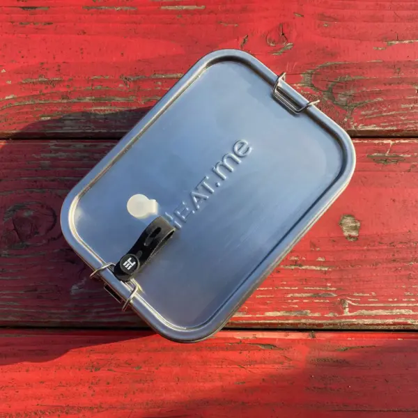 Premiuim lunchbox from HEAT.me with closed lid on a red wooden bench