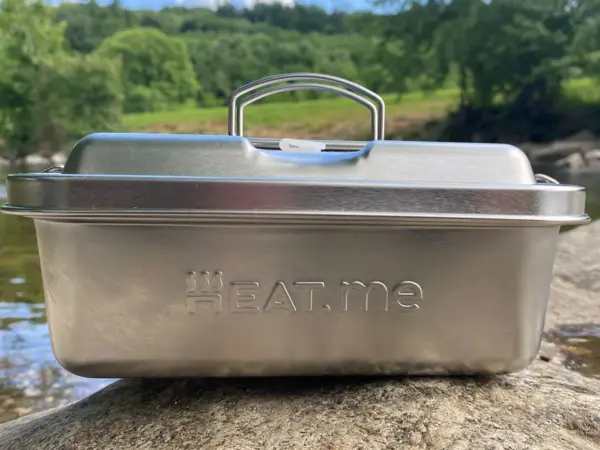 GRILL und CHILL >Lunchbox auf einem stein an einem Flussufer